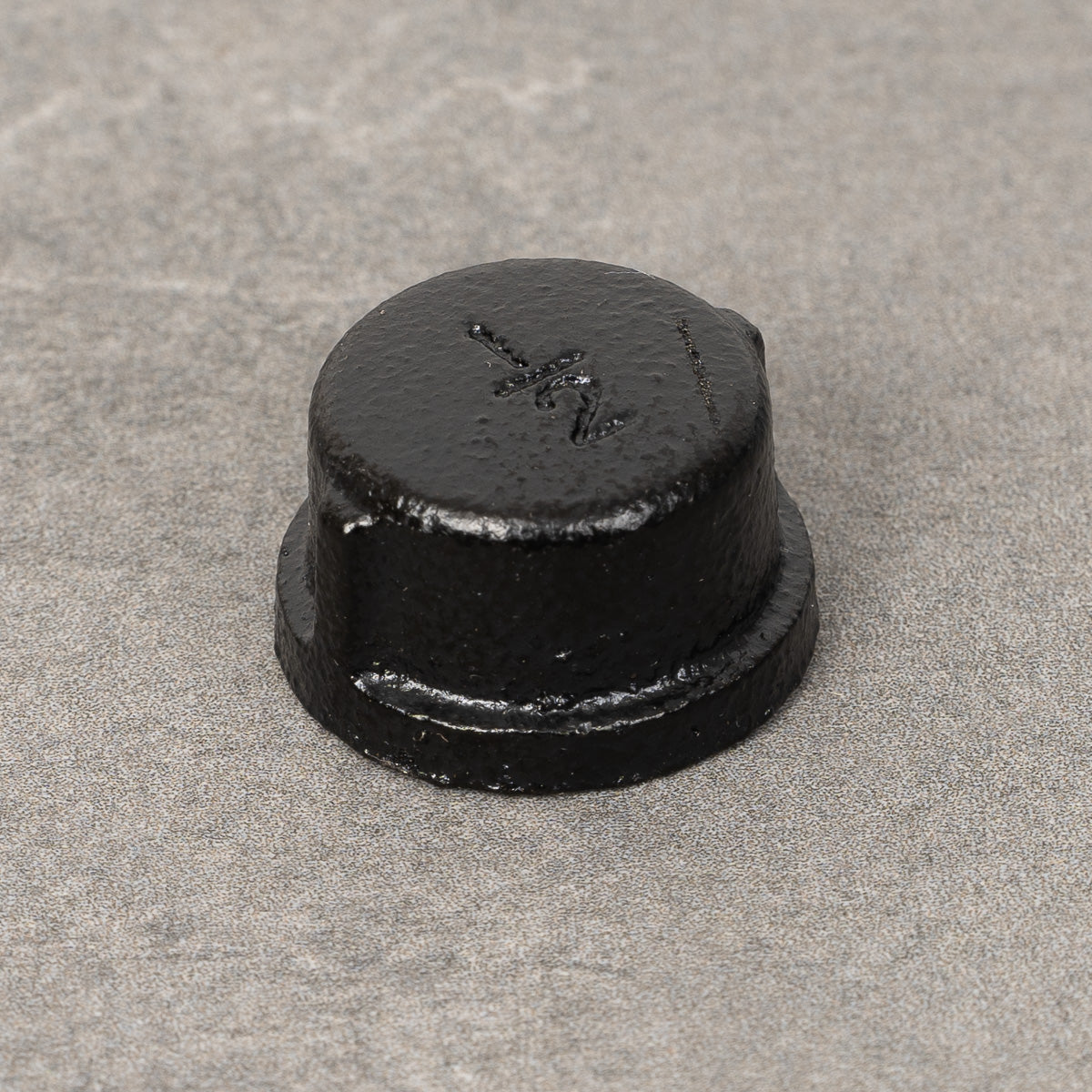 Ändmutter i svartlackerad finish, utvändig plugg med en diameter på 20 mm.